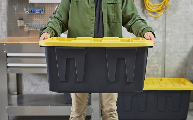 A Person Holding Project Source Commander Large 27 Gallons Stackable Tote with Standard Snap Lid