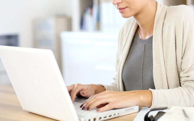 A Smiling Person Typing on a Laptop